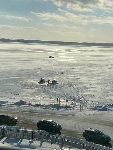 View of the hovercrafts during Lake Geneva Winterfest. The frozen lake has 2 hovercrafts that are parked on it waiting for guests.  
