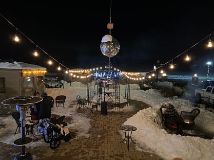 View of the Baker House setup at the Fire and Ice Bar during the Lake Geneva Winterfest. Cabanas, fire pits and heaters, surrounded with lots of snow on the ground.